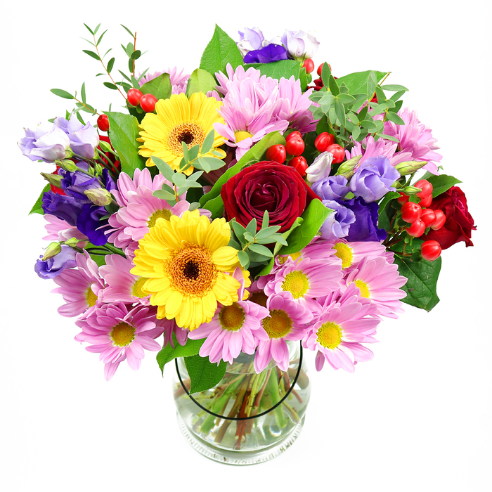In this image, a lush, mixed-colour bouquet rises proudly from a clear glass vase, positioned against a pure white background that gives it a gallery-like clarity. The arrangement is layered and full, starting with a cluster of deep red roses at the centre, their tightly folded petals unfolding like soft velvet, conveying a quiet sense of romance. Framing these are two bright yellow gerbera daisies with dark, textural centres that draw the eye and give the bouquet a happy, sunlit character, much like an afternoon wander around East Sheen's leafy residential streets. Surrounding these focal blooms, numerous pink daisies or chrysanthemums gather in loose, generous clusters; each blossom, with its fine petals and dainty yellow centre, softens the overall palette and adds a comforting, almost nostalgic charm. Threaded elegantly through the pinks and reds are purple and lavender lisianthus, their bell-shaped blooms and gently twisting buds adding height, depth, and an air of contemporary elegance. Small bunches of round, bright red hypericum berries punctuate the design, offering a glossy counterpoint to the soft petals and giving the arrangement a playful, modern detail. The bouquet is anchored by a wealth of green foliage-some leaves broad and polished, others more delicate and airy-creating a layered, natural framework. Through the glass vase, the stems are visible, neatly cut and arranged in clear water, showcasing careful, expert conditioning you would expect from an established East Sheen florist. The lighting is bright but soft, revealing each flower's texture and colour without glare. This arrangement feels ideal for celebratory occasions-birthdays, thank-yous, or congratulations on local milestones such as a new shop opening off Upper Richmond Road-bringing a sense of joy and fresh garden beauty indoors.